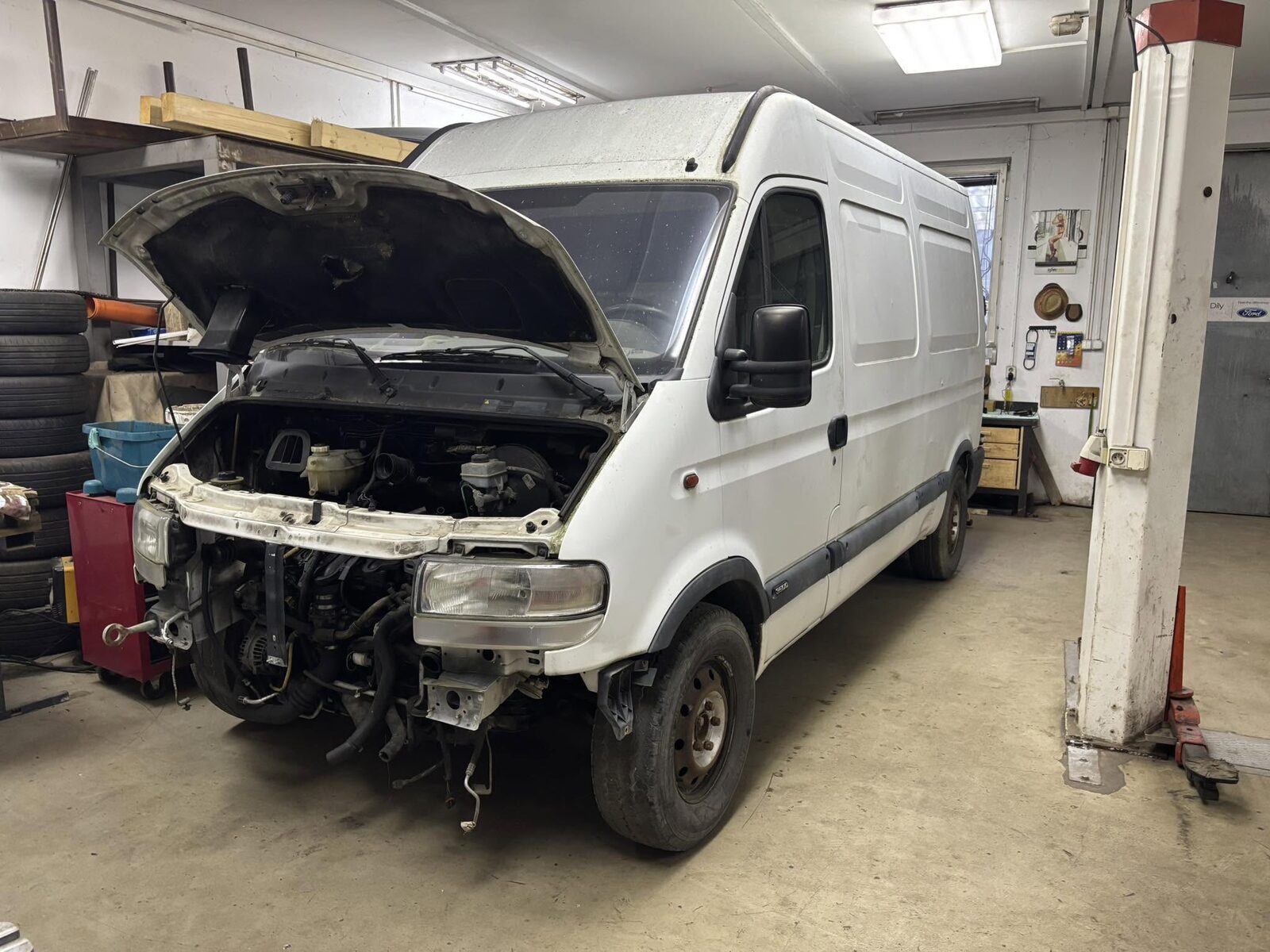 Dodávka s rozebraným předkem na opravě v dílně autoservisu v Ořechově
